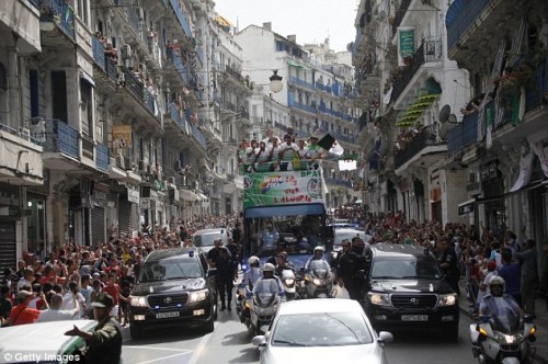 Homecoming: The Algerian squad are paraded through Algiers on an open-top bus on Wednesday
